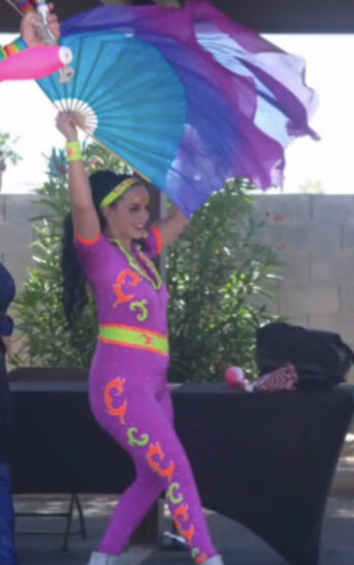 Performer in neon bodysuit with silk fans