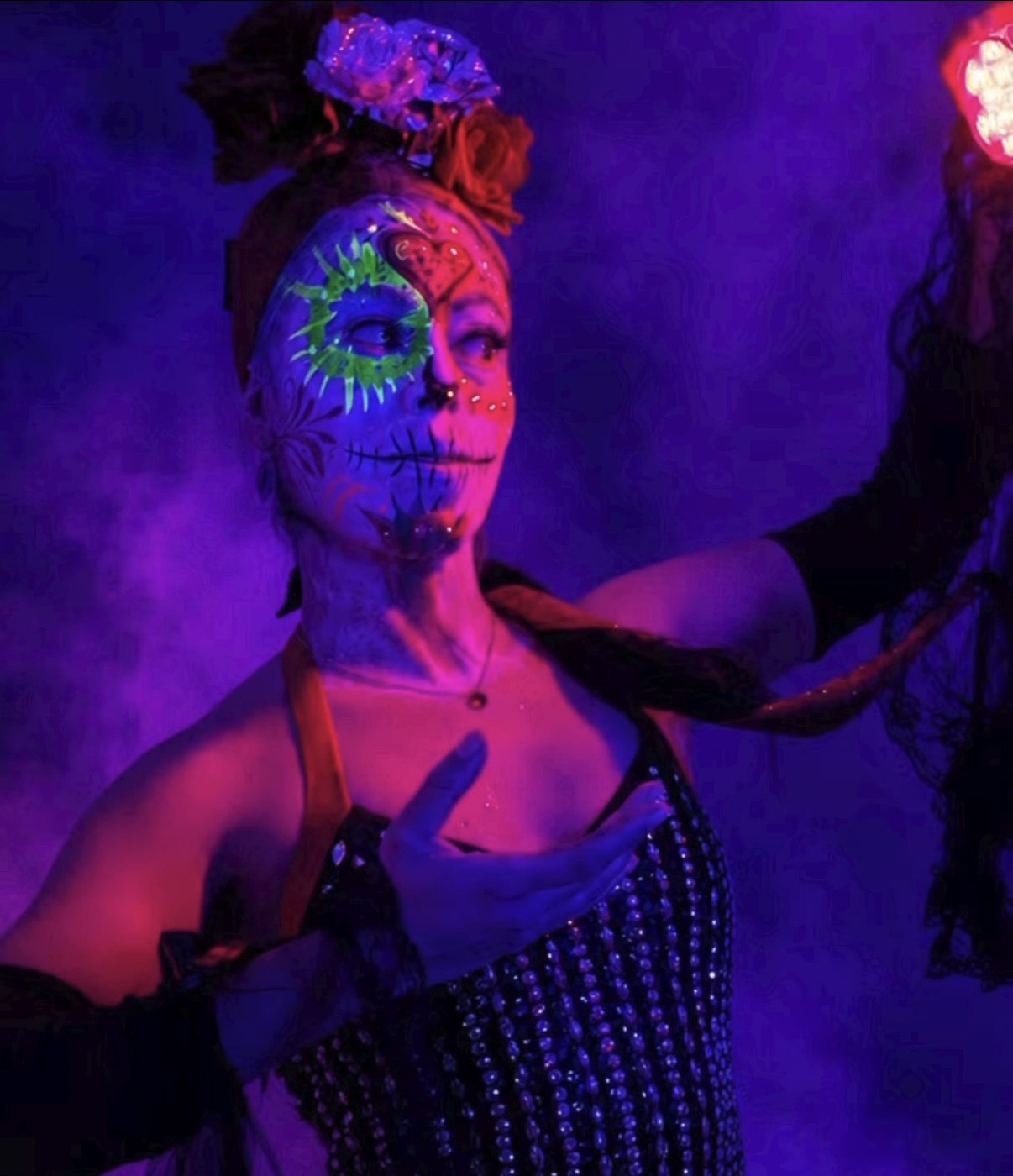 UV sugar skull reaching up under purple glow